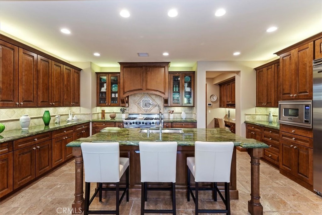 41 Cassis Circle Rancho Mirage, CA 92270 - Photo 21 of 74 a kitchen with kitchen island granite countertop a sink and wooden cabinets