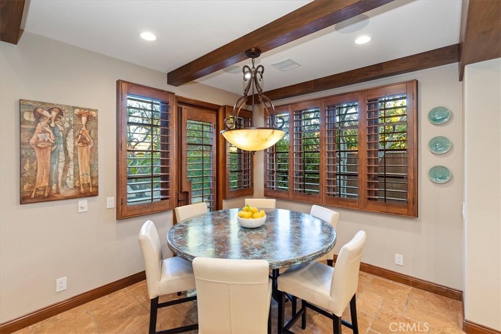 41 Cassis Circle Rancho Mirage, CA 92270 - Photo 23 of 74 a dining room with furniture a chandelier and wooden floor