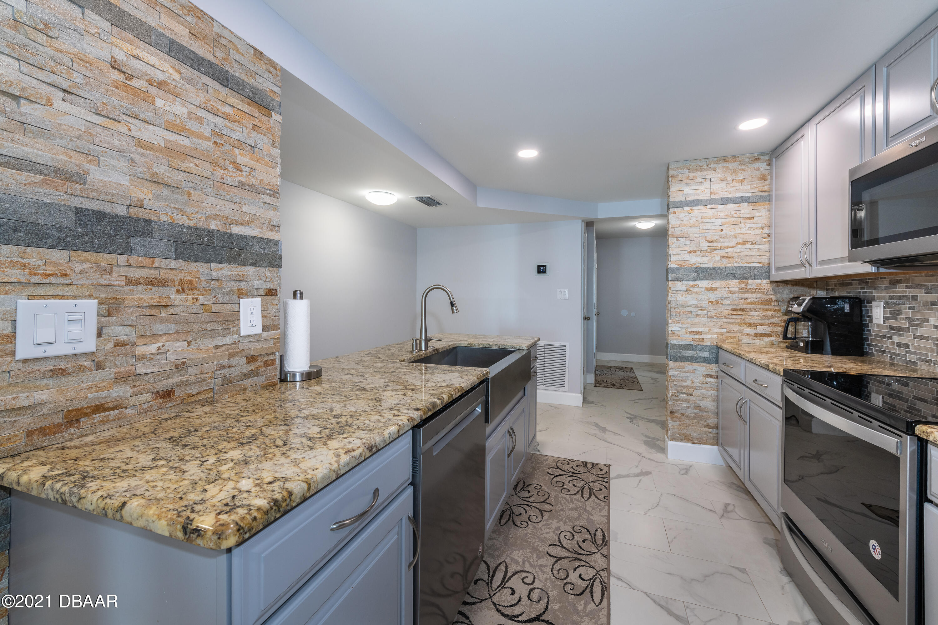 1275 Ocean Shore Boulevard, Unit 307 Ormond Beach, FL 32176 - Photo 6 of 24 a kitchen with stainless steel appliances granite countertop a sink stove and cabinets