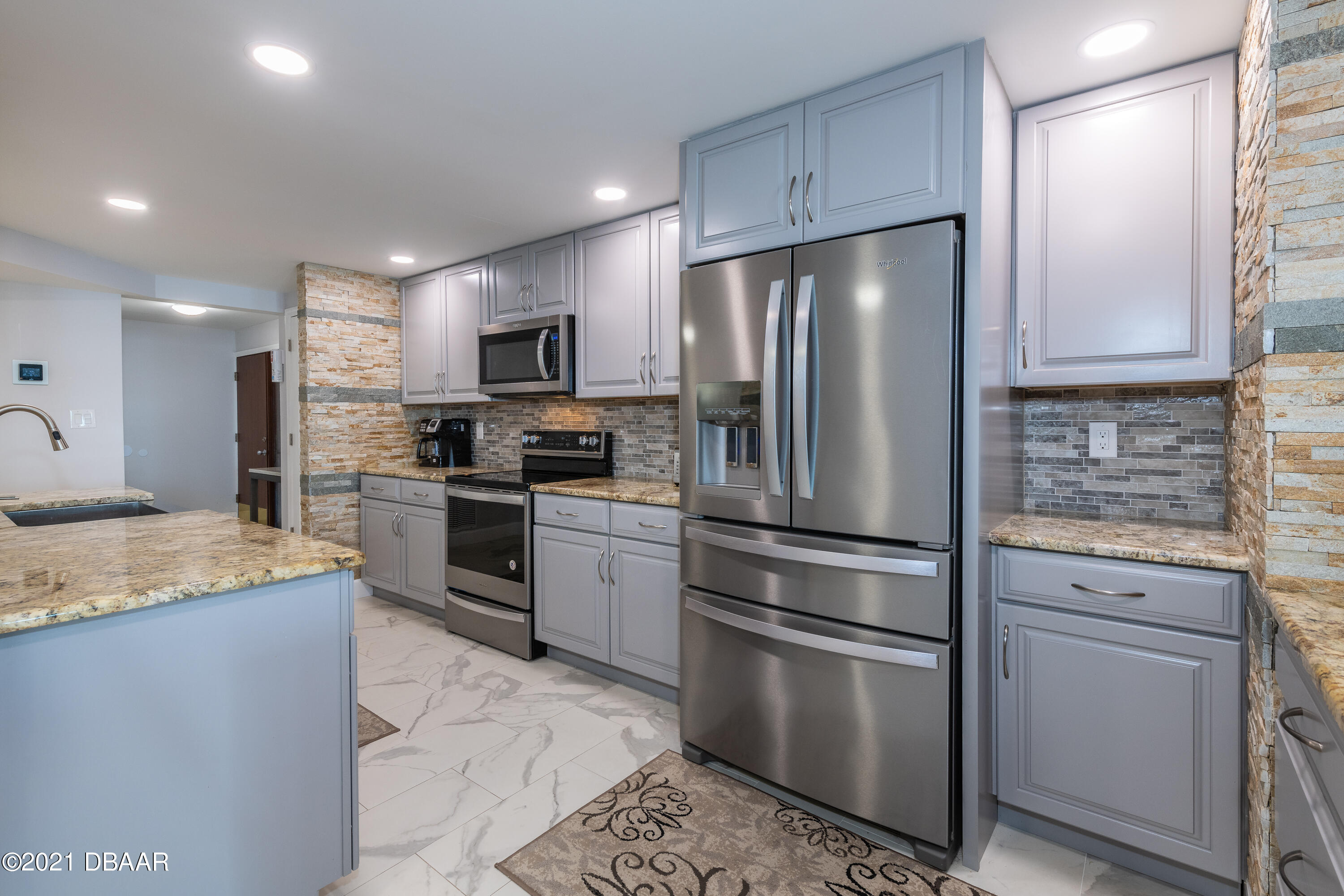 1275 Ocean Shore Boulevard, Unit 307 Ormond Beach, FL 32176 - Photo 7 of 24 a kitchen with granite countertop stainless steel appliances and refrigerator