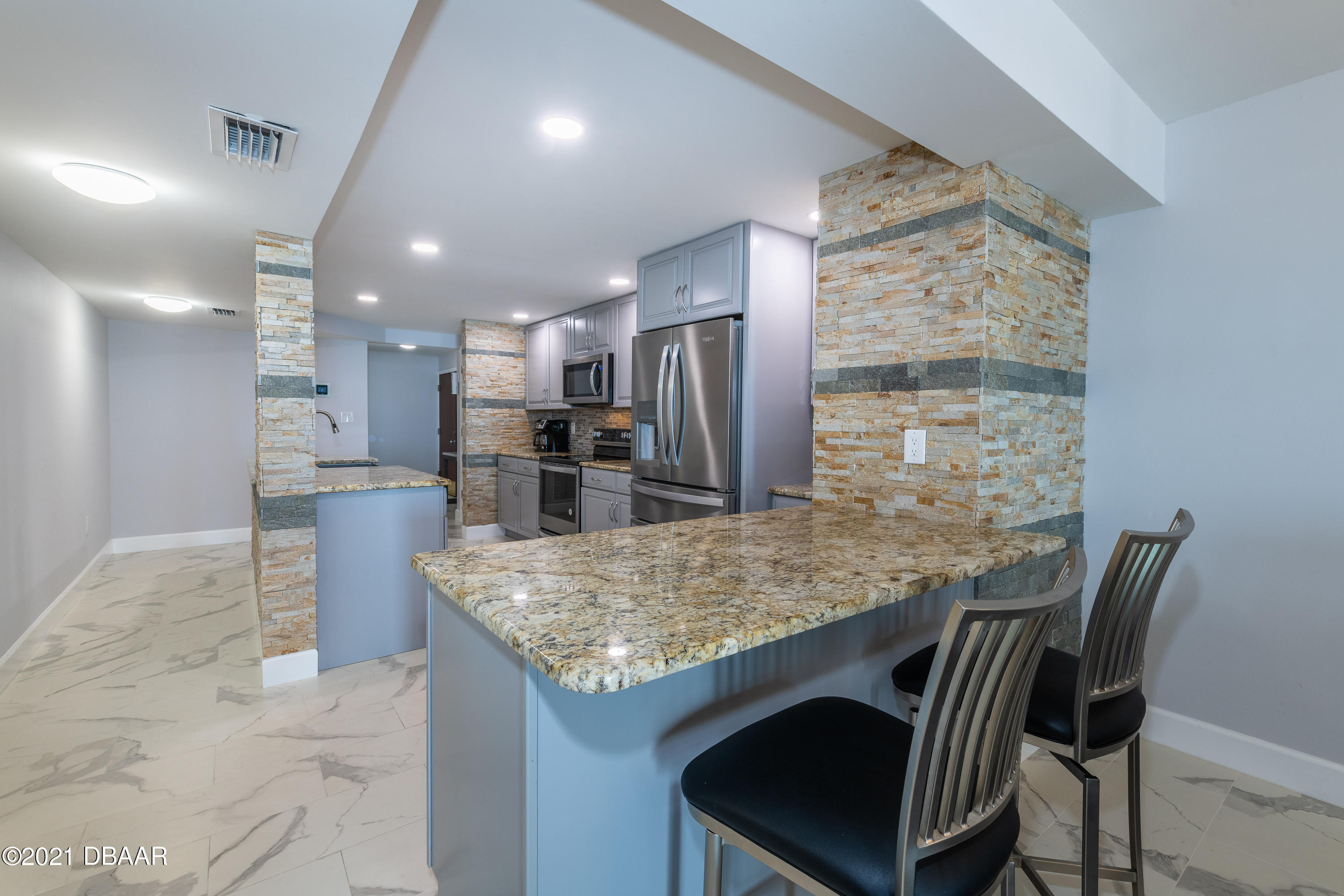 1275 Ocean Shore Boulevard, Unit 307 Ormond Beach, FL 32176 - Photo 8 of 24 a kitchen with kitchen island a counter top space appliances and cabinets