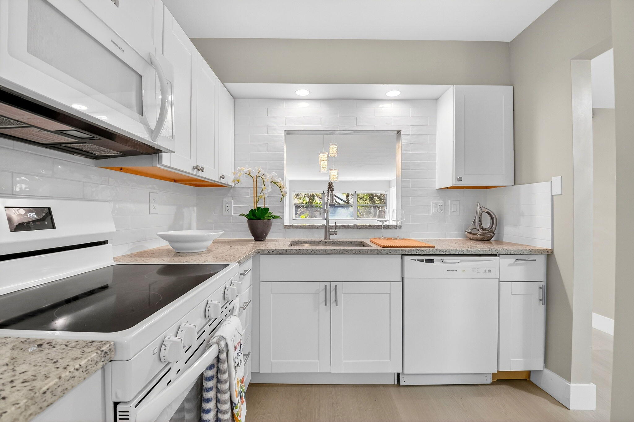 2018 Southwest 29th Court, Unit 642 Delray Beach, FL 33445 - Photo 6 of 23 a kitchen with granite countertop a sink dishwasher a stove and white cabinets