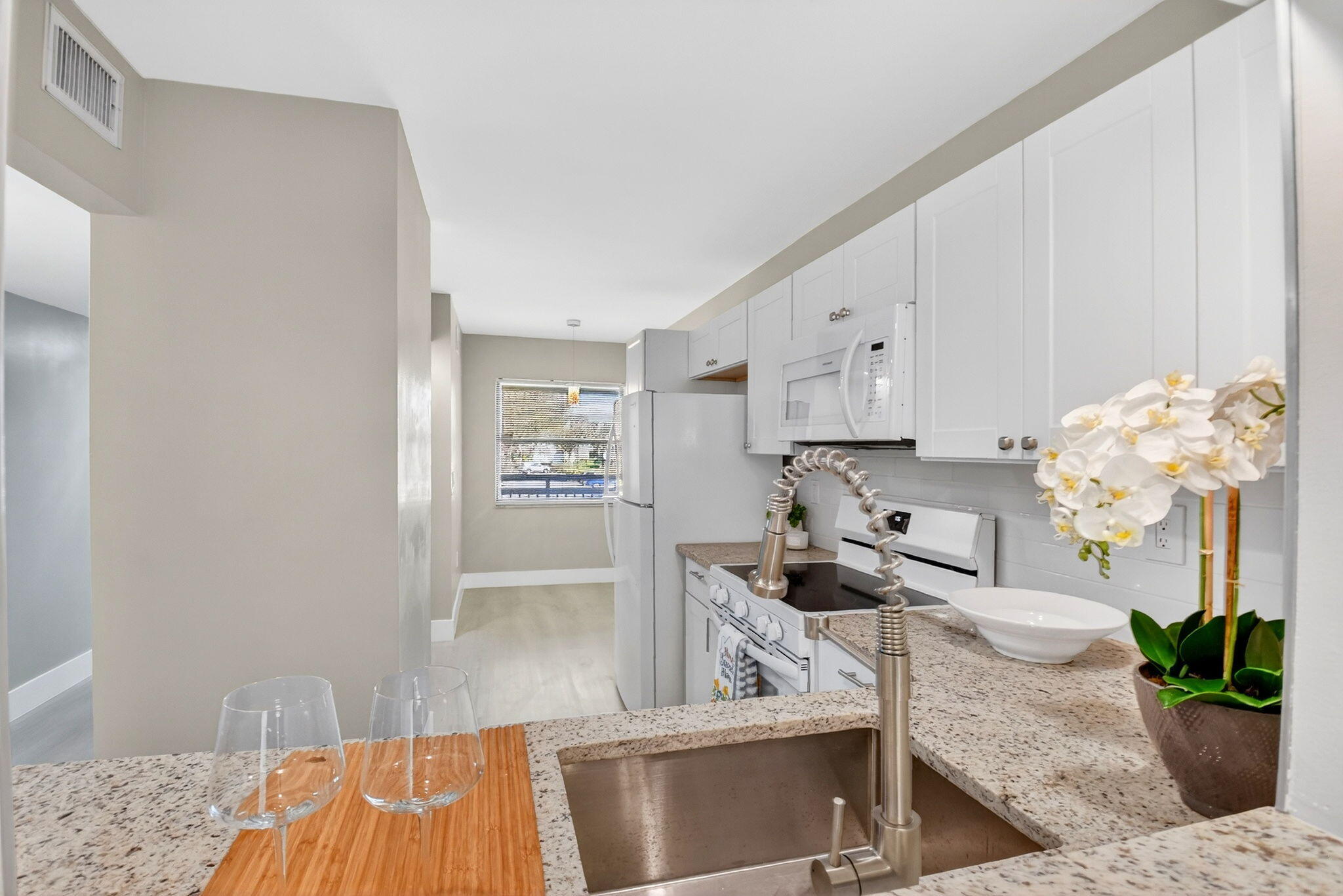 2018 Southwest 29th Court, Unit 642 Delray Beach, FL 33445 - Photo 7 of 23 a kitchen with granite countertop white cabinets and stainless steel appliances