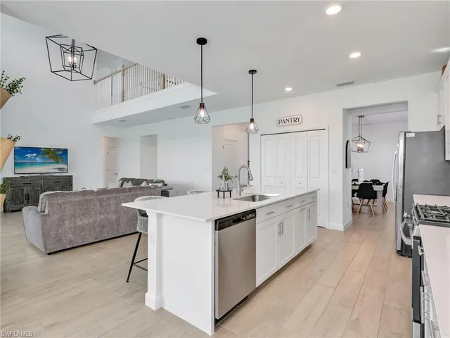 a large white kitchen with a lot of counter space and a sink