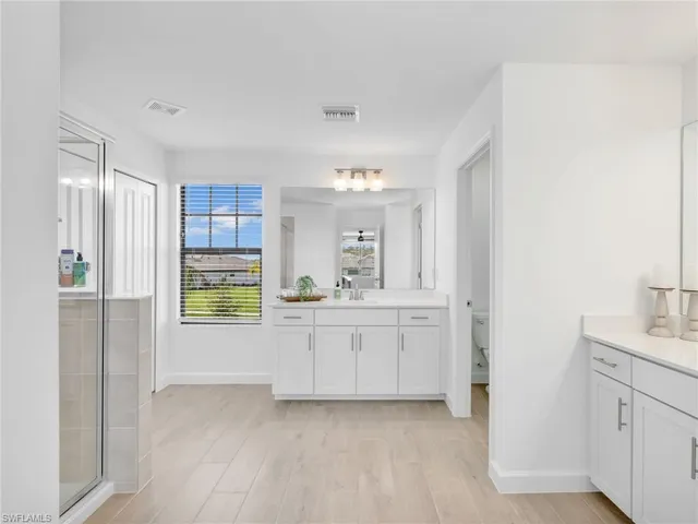 a bathroom with a granite countertop sink mirror and shower