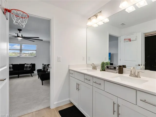 a en suite bathroom with a double vanity sink and a mirror