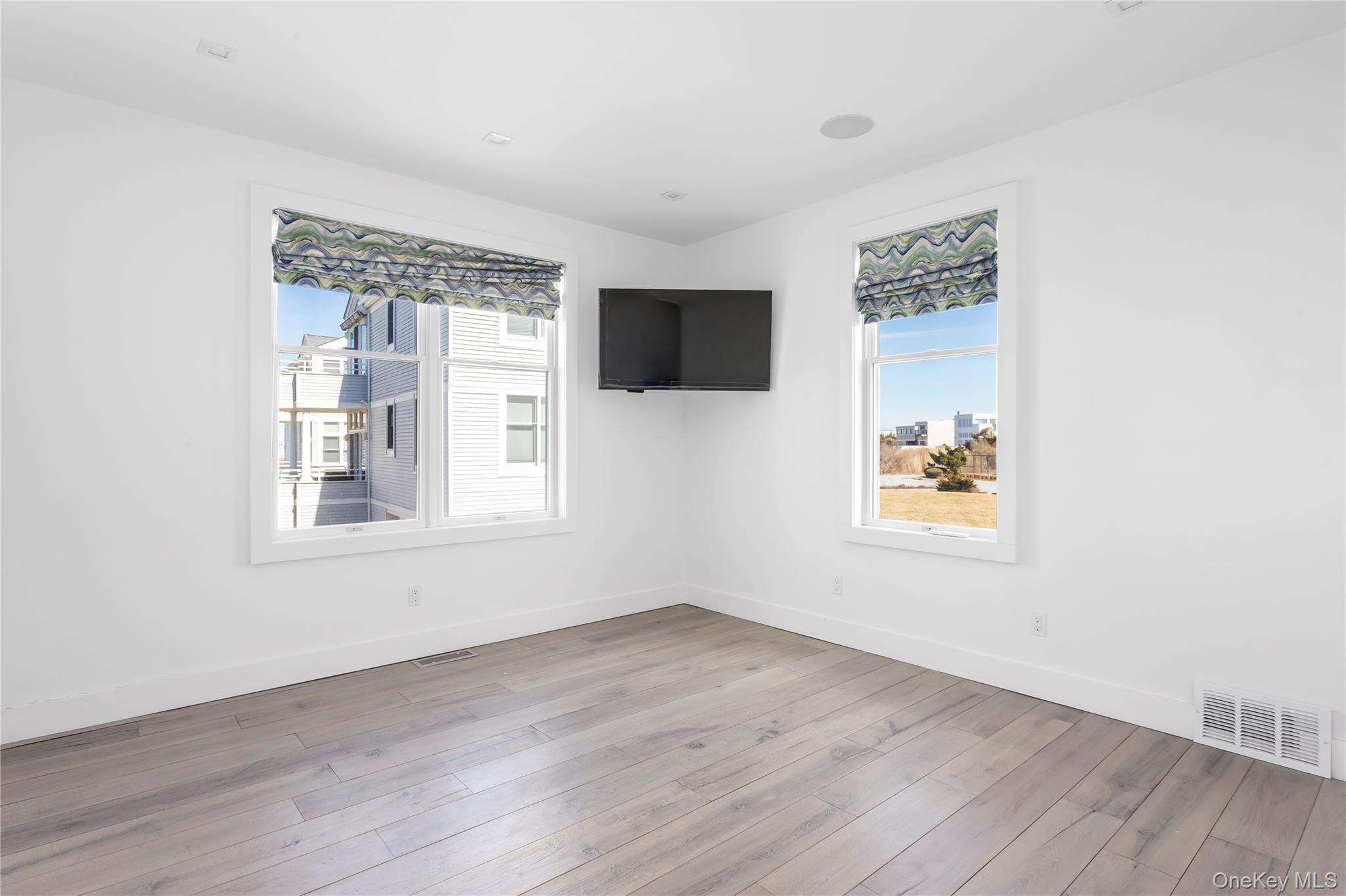 580 Dune Road, Unit 5 Westhampton, NY 11978 - Photo 18 of 22 a view of an empty room with wooden floor and a window