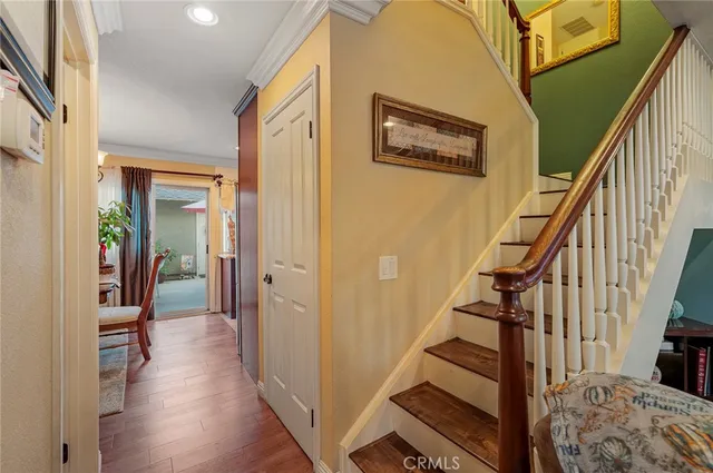 a view of a hallway with wooden floor and stairs