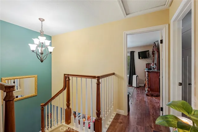 a view of a hallway with wooden floor and staircase