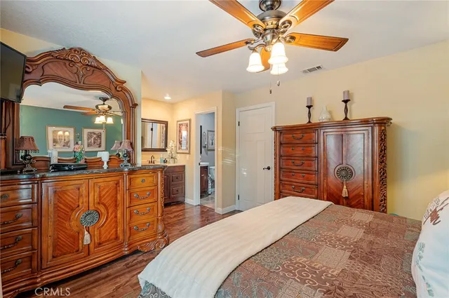 a bedroom with a bed dresser and a chandelier