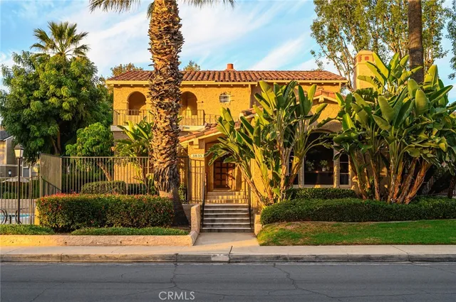 a front view of a house with a garden and trees