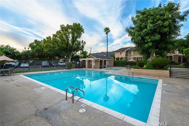 a view of a swimming pool with a yard and trees