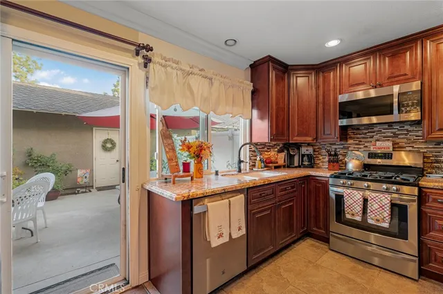 a kitchen with stainless steel appliances granite countertop a stove a sink and a microwave