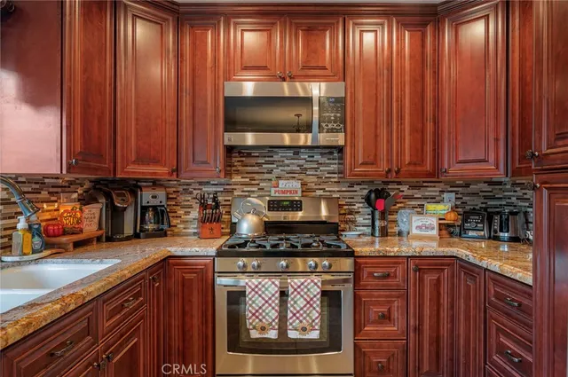 a kitchen with stainless steel appliances a stove a sink and a microwave