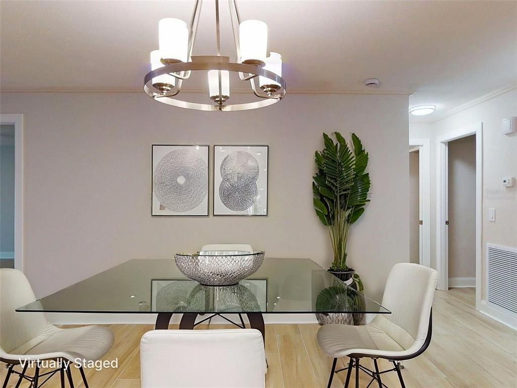 636 Boca Ciega Point Boulevard South St. Petersburg, FL 33708 - Photo 21 of 96 a view of a dining room with furniture a chandelier and wooden floor