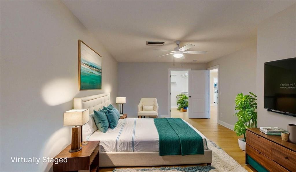 636 Boca Ciega Point Boulevard South St. Petersburg, FL 33708 - Photo 39 of 96 a bedroom with a balcony a bed and a flat screen tv