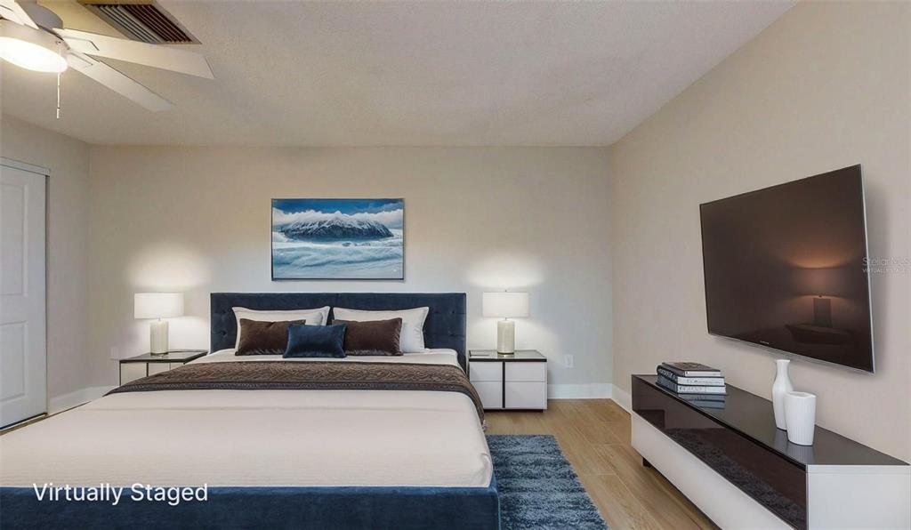 636 Boca Ciega Point Boulevard South St. Petersburg, FL 33708 - Photo 63 of 96 a bedroom with a bed and a flat screen tv