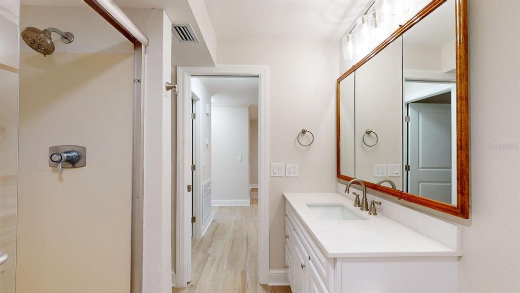 636 Boca Ciega Point Boulevard South St. Petersburg, FL 33708 - Photo 68 of 96 a bathroom with a sink a mirror a vanity and a shower