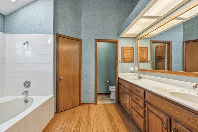 a spacious bathroom with a granite countertop tub sink and mirror