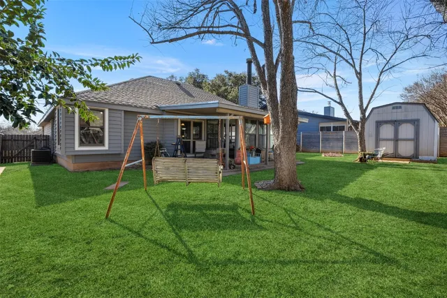 a view of a house with a backyard and a tree