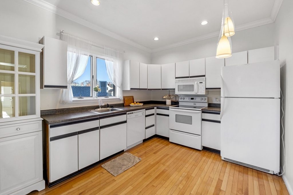 a kitchen with granite countertop white cabinets and white appliances