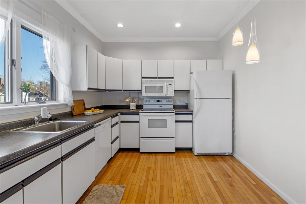 42 Broad Street, Unit 4 Salem, MA 01970 - Photo 8 of 33 a kitchen with a sink white cabinets and white appliances