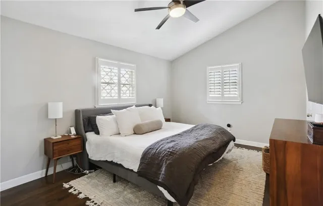 a bedroom with a bed tv and a window