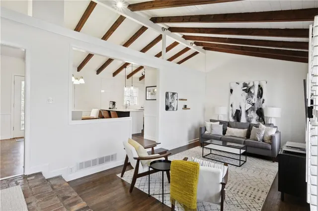a living room with furniture a flat screen tv and a window