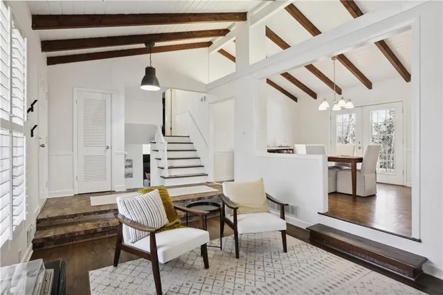 a kitchen with stainless steel appliances a sink a stove a refrigerator cabinets and dining table