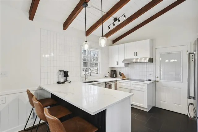 a kitchen with kitchen island white cabinets and stainless steel appliances
