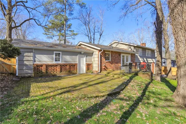 a view of a house with a big yard and large tree and wooden fence