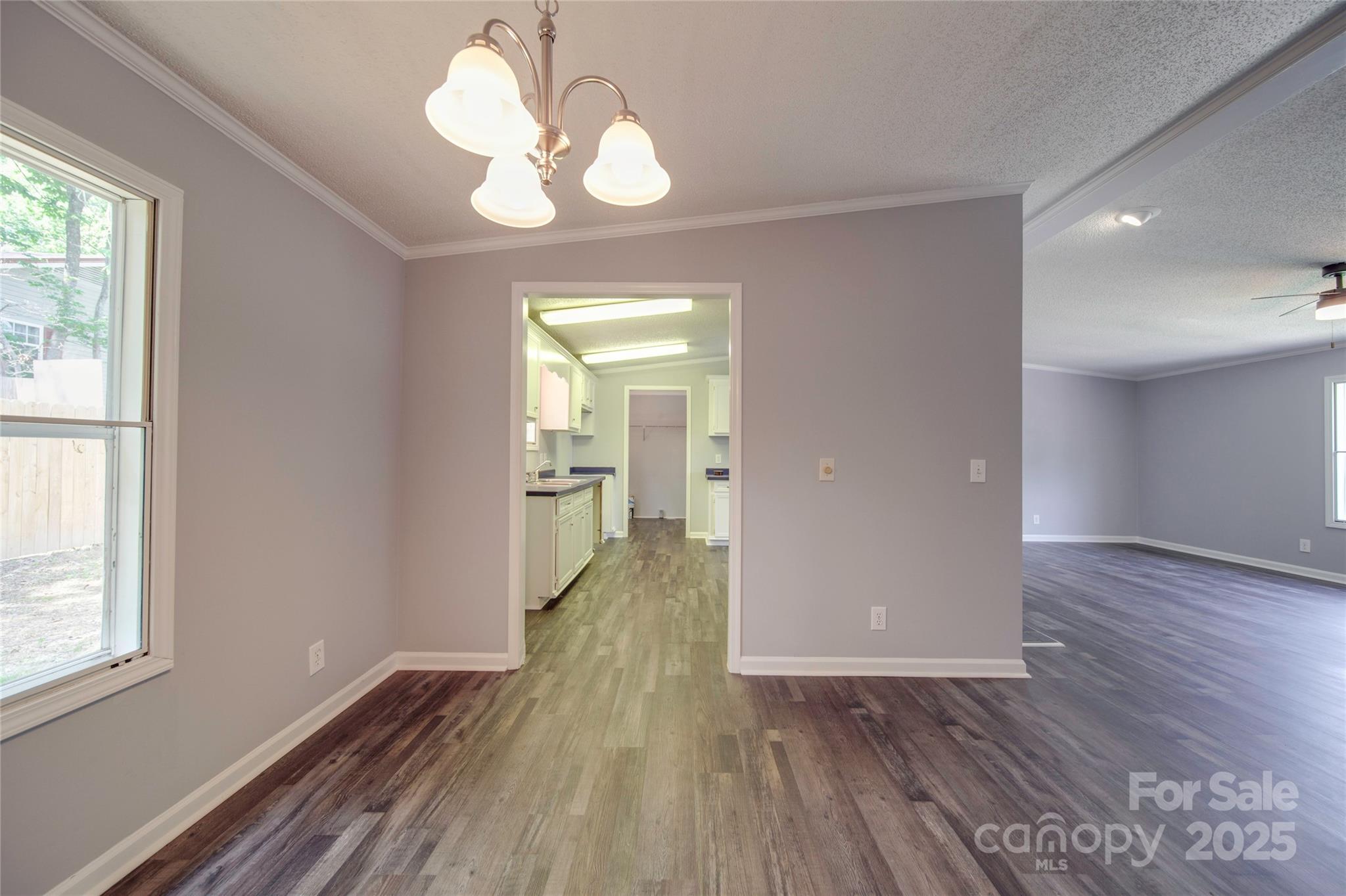 355 Shoreline Road New London, NC 28127 - Photo 13 of 22 a view of a hallway with wooden floor and a chandelier