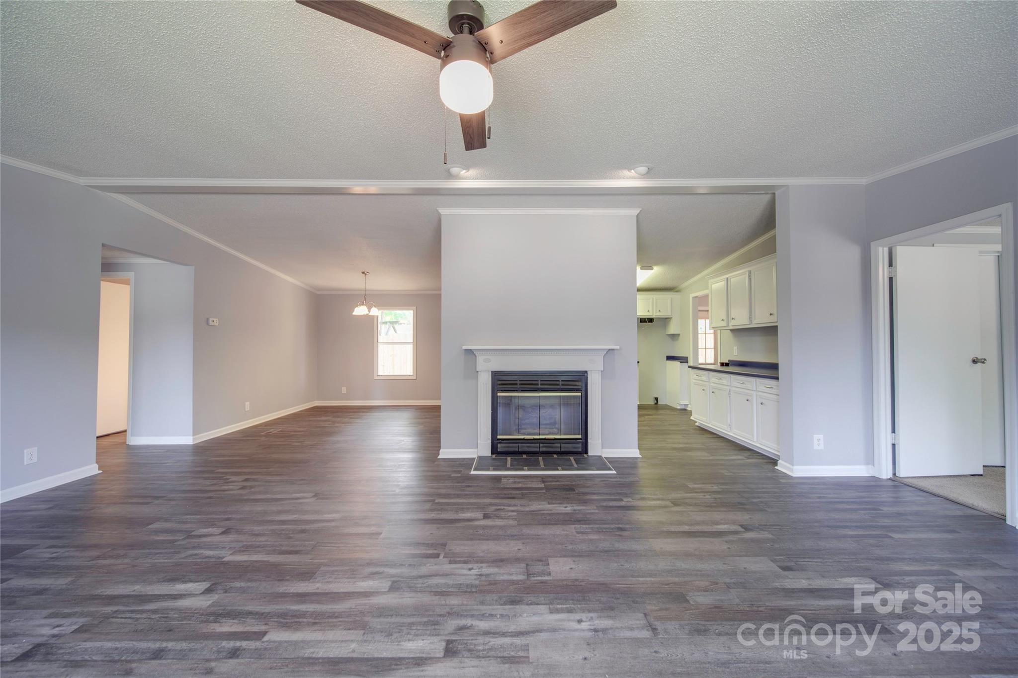 355 Shoreline Road New London, NC 28127 - Photo 5 of 22 an empty room with wooden floor fireplace and windows
