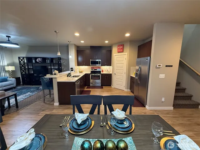 a dining room with wooden floor a chandelier a glass table and chairs