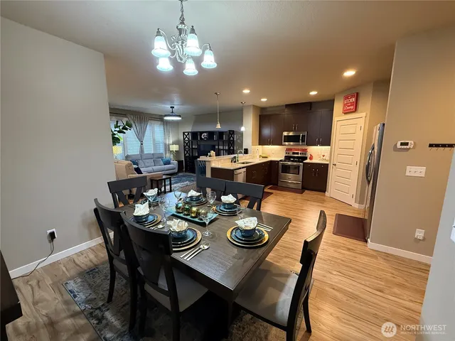 a kitchen with stainless steel appliances kitchen island granite countertop a sink refrigerator and cabinets