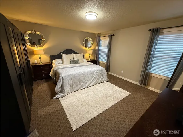a bedroom with a bed and a large mirror