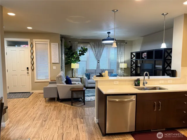 a kitchen with kitchen island granite countertop a sink and a refrigerator