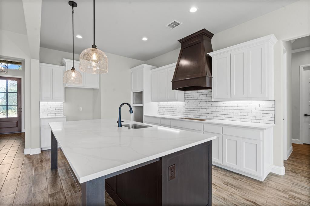 1005 Lilly Lane Weatherford, TX 76088 - Photo 13 of 34 a kitchen with a sink a counter space and cabinets