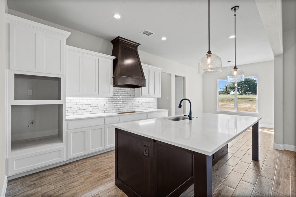 1005 Lilly Lane Weatherford, TX 76088 - Photo 14 of 34 a kitchen with a sink cabinets and wooden floor