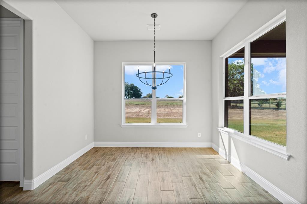 1005 Lilly Lane Weatherford, TX 76088 - Photo 15 of 34 a view of an empty room with a window and wooden floor