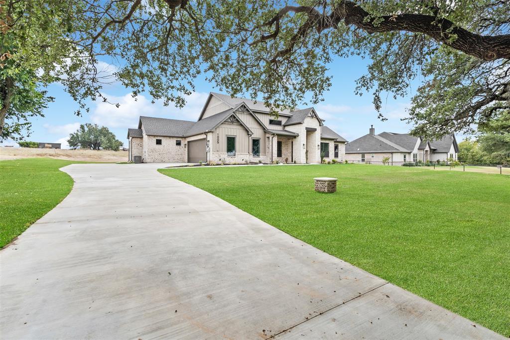 1005 Lilly Lane Weatherford, TX 76088 - Photo 2 of 34 a front view of a house with a yard and garage