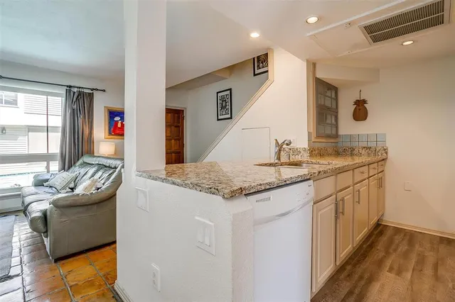 a kitchen with stainless steel appliances granite countertop a sink and a refrigerator