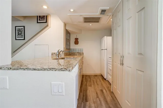 a bathroom with a granite countertop sink a mirror and shower
