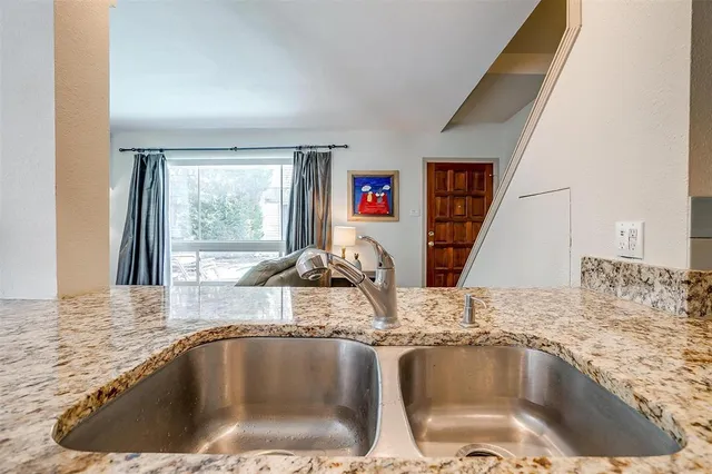 a view of a kitchen counter top a sink and dishwasher with wooden floor