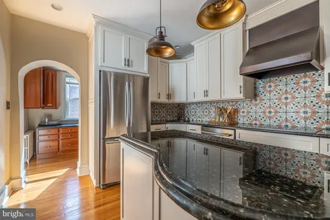 a kitchen with stainless steel appliances granite countertop a refrigerator a sink and a stove