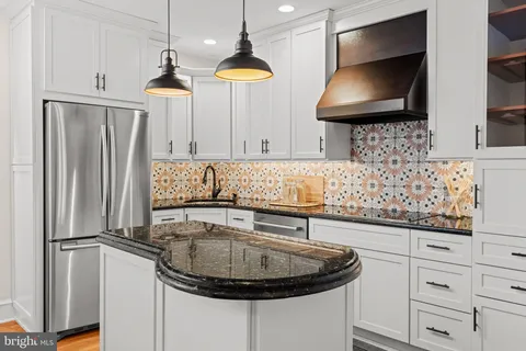 a kitchen with stainless steel appliances granite countertop a sink a refrigerator and a stove