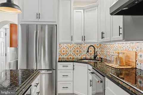 a kitchen with granite countertop a sink and a refrigerator