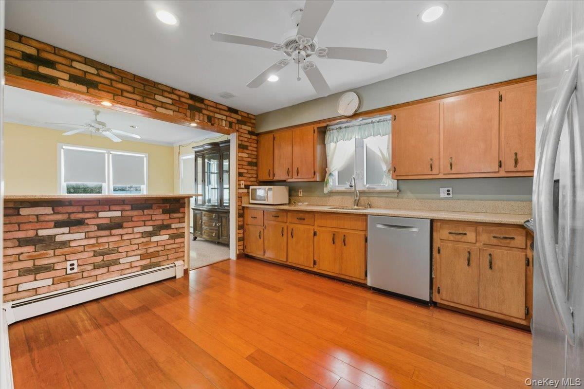 401 West Walnut Street, Unit UPPR Long Beach, NY 11561 - Photo 7 of 17 a kitchen with granite countertop wooden cabinets and white appliances