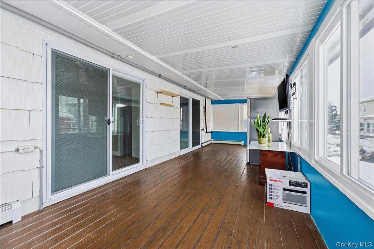 401 West Walnut Street, Unit UPPR Long Beach, NY 11561 - Photo 9 of 17 a view of an empty room with wooden floor and a window