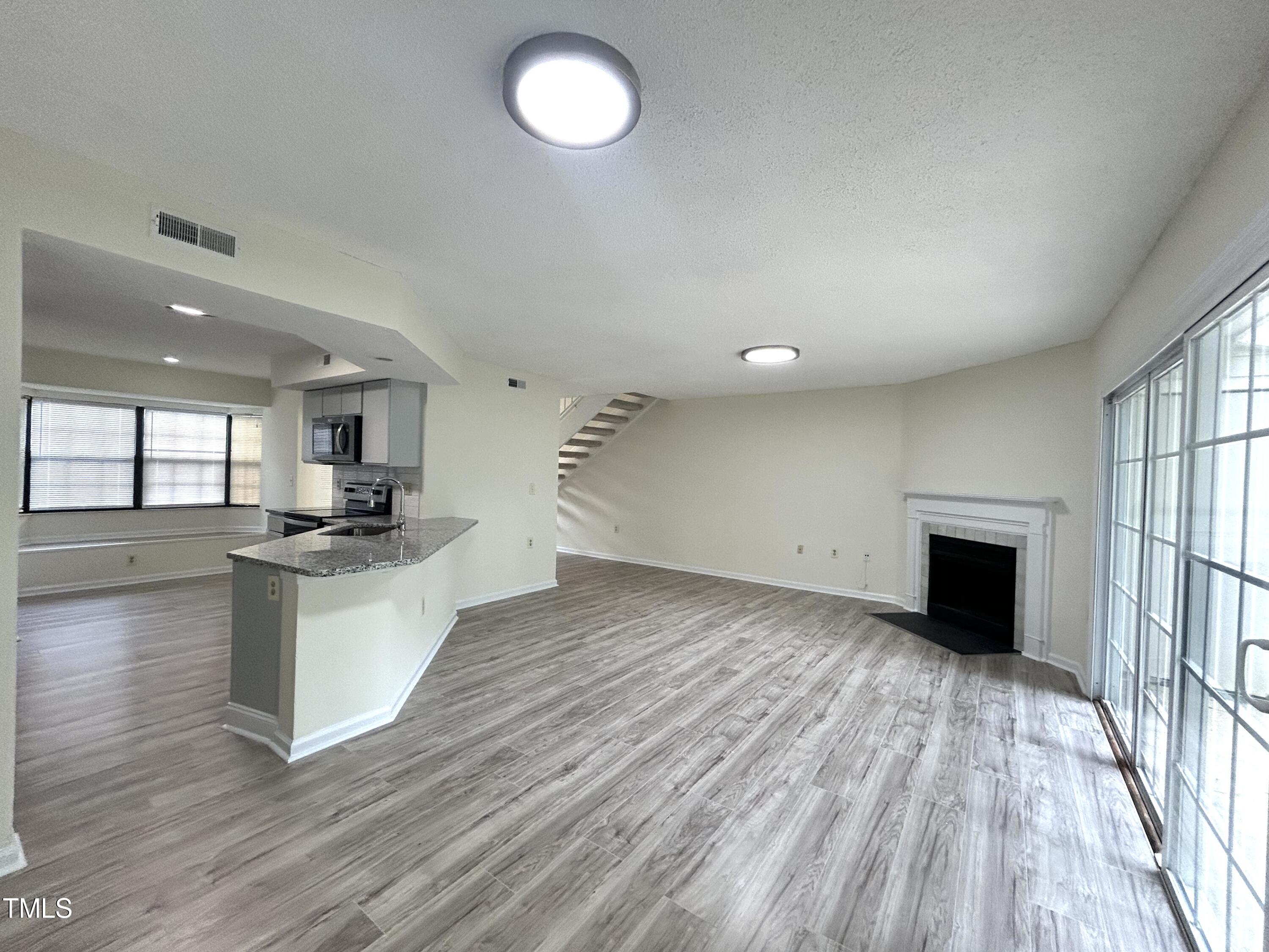 2426 Condor Court Raleigh, NC 27615 - Photo 4 of 28 a large kitchen with stainless steel appliances granite countertop a stove and a wooden floors